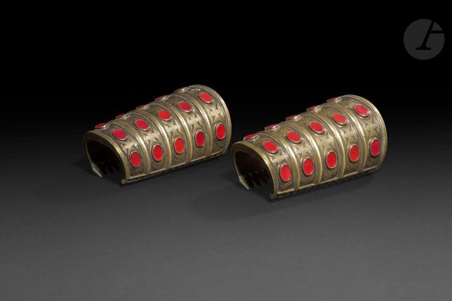 Paire de bracelets manchettes bilezik, Turkmenistan, Yomud, XXe siècle
Bracelets en argent partiellement doré, ouverts, achevés de têtes de serpent stylisées, ornés de cinq registres incisés de motifs courbes et sertis de quatre cabochons de pierre orange.
Hauteur : 7,2 cm ; Longueur : 13,5 cm ; Diamètre : 8,5 cm ; Poids brut : 830 g

A pair of bracelets bilezik, Turkmenistan, 20th century