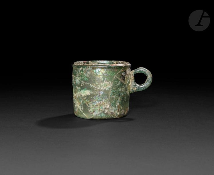 Gobelet en verre avec anse appliquée, Iran, XIe - XIIe siècle
Gobelet cylindrique en verre turquoise translucide à fond plat et parois verticales.
Hauteur : 8,4 cm ; Diamètre : 8,6 cm
État : restaurations, irisations.

Provenance : ancienne collection Christopher Sheppard.

A glass beaker with handle, Iran, 11th – 12th century