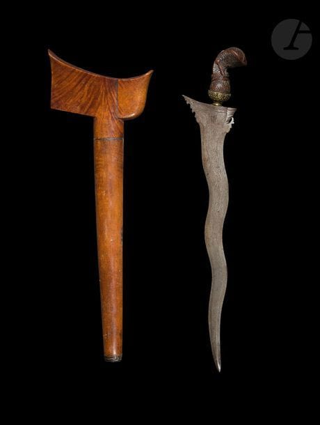 Poignard, kriss, Indonésie, XIXe siècle
Monture en bois sculpté d’un garuda stylisé, virole en métal doré à décor floral, lame serpentine damassée. Fourreau en bois uni à large wangka achevé par une agate sertie.
Longueur : 49 cm
État : poignée fendue, petit manque au bout du fourreau.

A dagger, kriss, Indonesia, 19th century