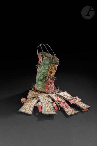 Sac et paires de sandales touaregs, Algérie, début XXe siècle
Sac cylindrique à franges en cuir de différentes couleurs orné de motifs géométriques, anses en cuir tressé. 33 x 15 cm ; - deux paires de sandales, nails, en cuir tressé de différentes couleurs, à motifs géométriques. Semelle tenue par un lien. Dim. semelle : 26,5 x 13 cm et 27 x 14 cm

A Tuareg bag and a pair of shoes, Algeria, early 20th century