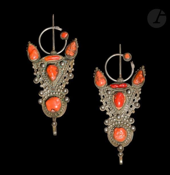 Paire de grandes fibules, abzim, Algérie, Grande Kabylie, Beni Yenni, début XXe siècle
De forme triangulaire en argent (bas titre) ciselé et rehaussé de grosses perles argent et de gros cabochons de corail à cercle achevé d’une tête animalière.
Longueur : 21 cm ; Largeur : 8,5 cm ; Poids brut : 365,24 g

A pair of silver fibulae, abzim, Algeria, Great Kabylia, Beni Yenni, early 20th century