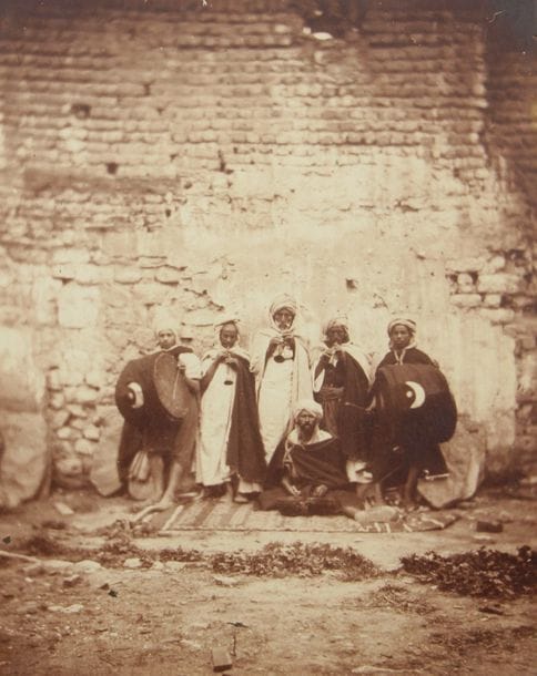 Félix  Moulin (1802-1875/79) 

Algérie, c. 1856. 

Musiciens du Sahara. Marchandes de kak. Fontaine près de la Porte Neuve et Remparts d'Alger. La Casbah, Oasis du vieux Biskra, Sahara. Mascara vue prise de la tête du pont.

Cinq (5) épreuves sur papier albuminé contrecollées sur cartons. Légendes manuscrites et tapuscrites sur étiquettes collées aux versos. Timbre sec "Lamiche et Moulin" (2). 

Formats : de 19 x 24,5 à 22 x 17 cm