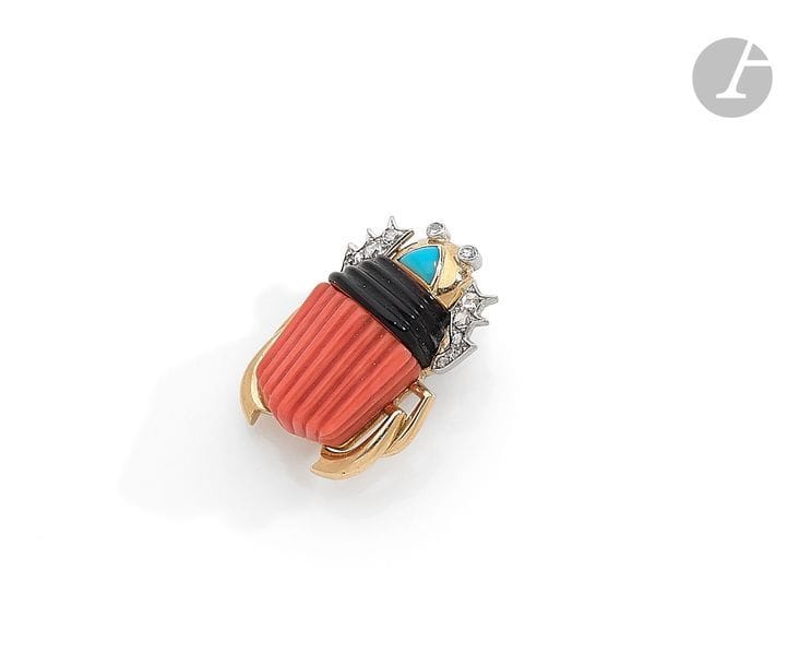 CARTIER. Clip de revers en or 18K (750) formant un scarabée, la tête et les pattes antérieures agrémentées de diamants ronds sur platine, sertie d’une turquoise cabochon, l’abdomen émaillé et corail godronné. Signé et numéroté. Dans un écrin de la Maison Cartier. Dimensions : 3 x 2 cm environ.
Poids brut : 17,9 g