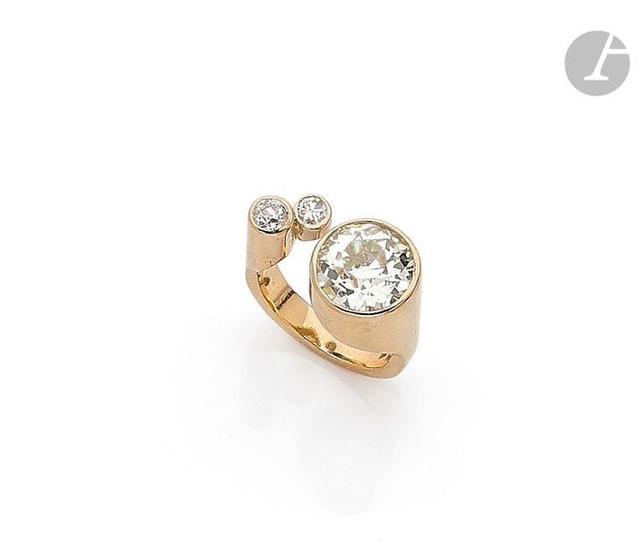 JEAN VENDOME (attribuée à). Bague Tour en or 18K (750), ornée d’un côté d’un diamant rond de taille ancienne pesant 3,34 cts, deux diamants ronds lui faisant face. Non signée. 
La bague accompagnée d’une copie de l’estimation (1989) pour assurance signée Jean Vendome. Tour de doigt : 48. 
Poids brut : 7,4 g