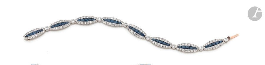 Bracelet en or 18K (750) et platine, articulé de 8 maillons ovales sertis d’une ligne de saphirs calibrés entre deux lignes de diamants ronds. Longueur : 18 cm environ. 
Poids brut : 17,1 g 