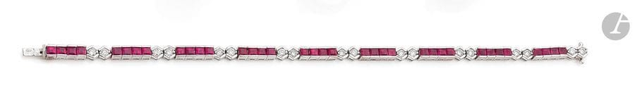 Bracelet ligne en or gris 18K (750), articulé de rubis calibrés scandés de diamants ronds. Longueur : 18 cm environ. 
Poids brut : 15,1 g