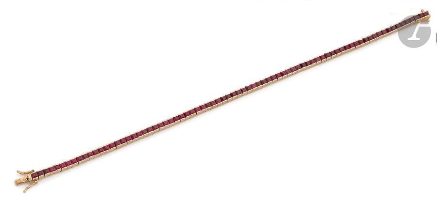 Bracelet ligne en or jaune 18K (750), orné de rubis calibrés. Longueur : 18 cm environ. 
Poids brut : 14 g