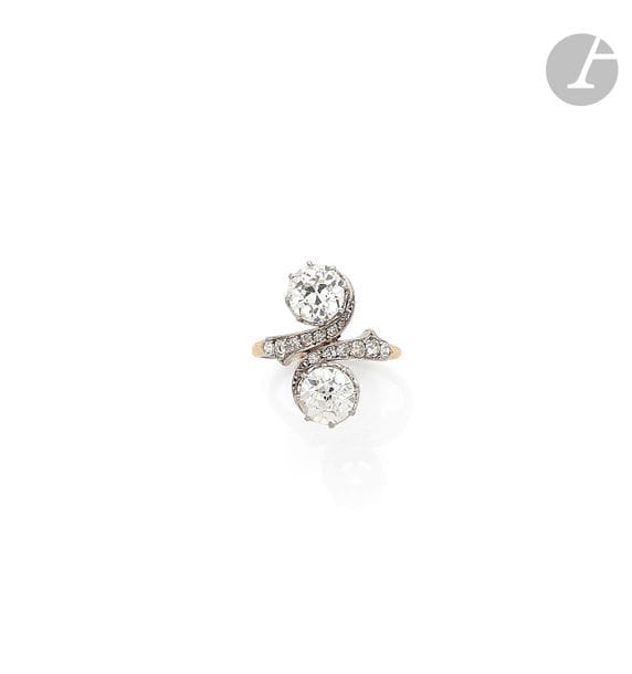 Bague toi et moi en or 18K (750) et platine, ornée de deux diamants ronds de taille ancienne, l’épaulement agrémenté de diamants plus petits. Travail du début du XXe siècle. Tour de doigt : 53 / 54.
Poids brut : 6,1 g (choc)