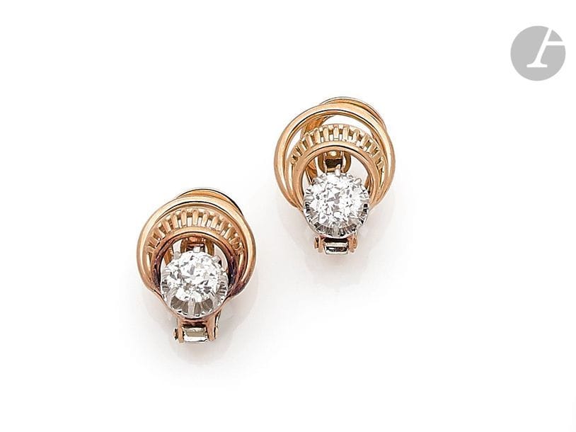 Paire de clips d’oreilles en fils d’or 18K (750), chacun orné d’un diamant de taille ancienne sur platine. Travail français des années 1950. 
Poids brut : 8,8 g