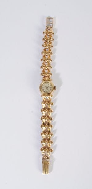 Montre de dame en or 18K (750), cadran rond, bracelet en or 18K articulé de maillons imbriqués. Travail français des années 1940. Poids brut: 32,6 g (remontoir métal)