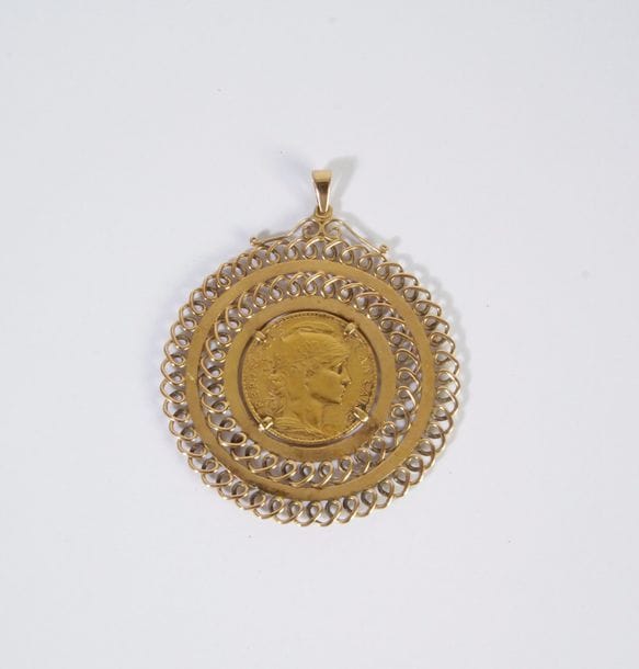 Pendentif en or 18K (750), ajouré en rosace, serti d'une pièce de 20 Francs or. Poids: 14,1 g
