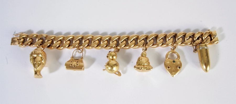 Bracelet en or 18K (750), maillons gourmette, retenant en pampilles, des charms en or 18K: une balle, un cœur, un Bouddha, un chat, un sac à main et une tête de femme. Poids brut: 62,1 g