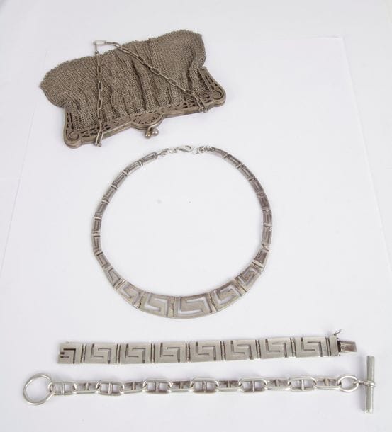 Lot en argent comprenant: un sac du soir en mailles tressées, un bracelet articulé de maillons en grecques et un bracelet articulé de maillons marine. Poids: 344,5 g (on joint un collier cassé)