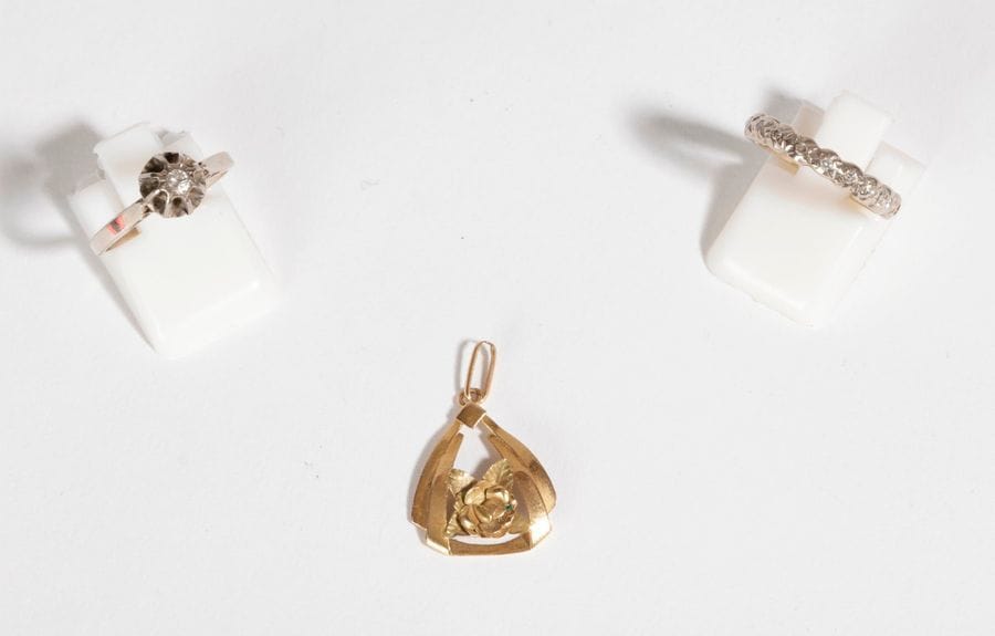 Lot de 3 bijoux en or 18K (750) comprenant: une demi-alliance sertie de petits diamants ronds, une bague solitaire ornée d'un diamant rond et un pendentif ciselé d'une rose. Poids brut: 6,4 g (manque)