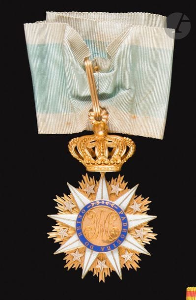PORTUGAL 
ORDRE DE VILA VICOSA, créé en 1819. 
Superbe étoile de commandeur, fabrication de luxe. 
En or et émail. Centre en deux parties. Cravate ancienne. 
81 x 50 mm - Poids brut : 36,8 g
Dans son écrin mouvementé garni de velours et soie, recouvert de papier façon maroquin frappé à l’or « LB » sous couronne de comte. 
T.T.B. (Manque une étoile émaillée sur les rayons). 

