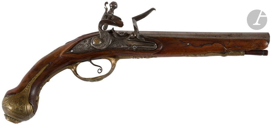 Pistolet à silex d’officier.
Canon rond à pans au tonnerre signé sur la bande « Lazarino Cominazzo ». Platine, chien col de cygne à corps plats, et batterie ciselée de rinceaux. Bassinet rond à pare étincelles en fer. Garnitures en laiton ciselé, découpé à décor de feuillages, bustes de femme et bouquets. Monture en noyer en partie sculpté. Crosse à long fût avec pièce de pouce gravée. Baguette en bois.
B.E. Italie, vers 1760.

