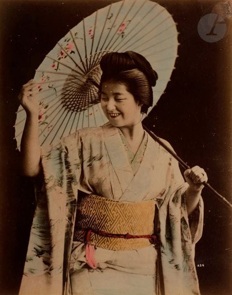 Kusakabe Kimbei (1841-1934) et divers
Japon, c. 1880. 
Musiciennes. Jeune fille à l’ombrelle. Geishas. Scènes de marché. Fleuriste. Marchand de chaussures. Fileuse. Cérémonie du thé. Tokyo, Satake Garden. Yokohama, Bentendori. Nikko Karamon. Kyoto. Kasugasha Nara. Karasaki no matsu otsu. Fuji. Lake of Hakone. Miyajima Aki. Moji. Castle of Fukuyama Gingo. Onomichi Bingo. Takaboko Nagasaki. Dancer of Shinto. Spinning wheel. 
Album in-4 oblong, plats en laque et nacre, composé 50 épreuves sur papier albuminé contrecollées sur cartons, rehaussées à l’aquarelle et légendées en bas en bandeau. 
Format moyen des épreuves : 19,5 x 25 cm