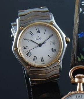 EBEL
Montre-bracelet d'homme en acier et or, la montre de forme ronde, cadran émaillé blanc, chiffres romains, guichet dateur à trois heures, mouvement à quartz, tour de poignet articulé. N° 1202-183909 Longueur : 17 cm.