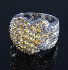 Bague ornée d'un motif coeur pavé de saphirs jaunes, entre des lignes de diamants. Poids brut : 16 g. (Manque un saphir).