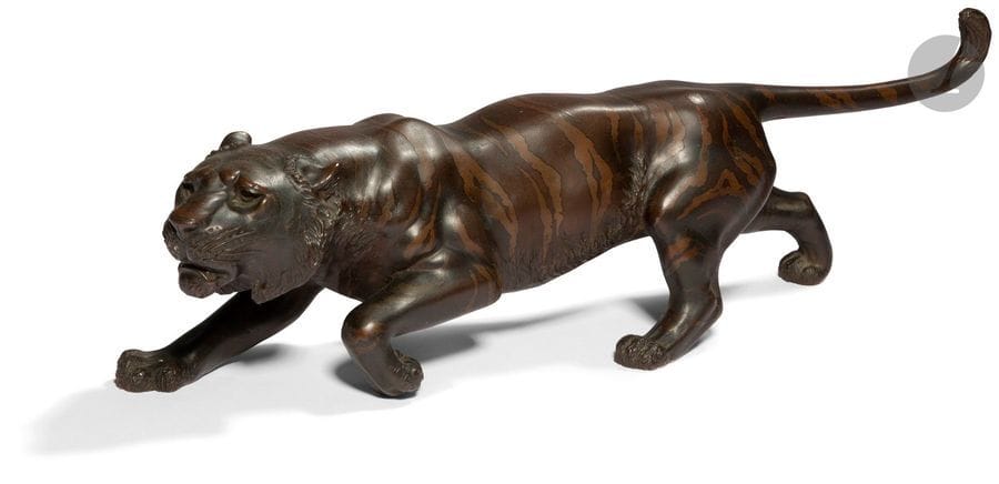 JAPON - Époque MEIJI (1868 - 1912)
Statuette en bronze à patine brune de tigre marchant à l’affut, la queue dressée en arrière. Signée. 
L. 35,5 cm
