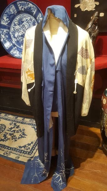 JAPON - XXe siècle
Ensemble de deux vêtements japonais :
- Veste Haori en soie noire, décorée à l’intérieur en soie jaune de motifs d’éventails.
- Yukata en soie bleu foncé, à décor des branches de bambou à la partie inférieur.
