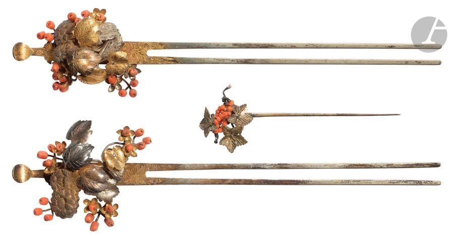 JAPON - XIXe siècle
Trois épingles à cheveux en cuivre, laiton doré et shibuichi et perle de corail formant feuilles d’érable parsemées de fruits. 
H. de 8,2 à 18,7 cm