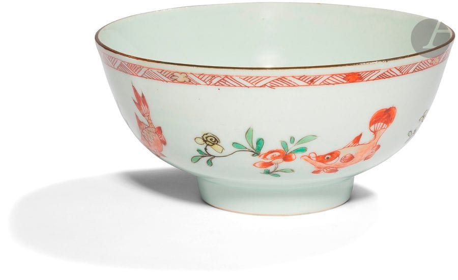 CHINE - Époque KANGXI (1662 - 1722)
Bol en porcelaine émaillée en rouge de fer, vert jaune et or, à décor de poissons et de tiges fleuries. 
Diam. 15 cm