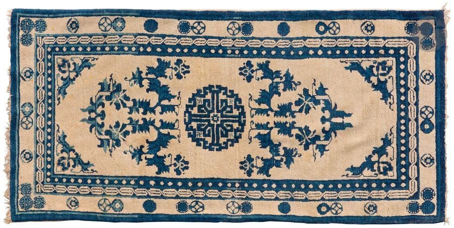 CHINE - Début XXe siècle
Tapis en laine à motif central en cercle crannelé entouré de deux rinceaux fleuris stylisés, petite bordure en double S, bordure ivoire à motif chinois répétitif bleu.
79 x 160 cm