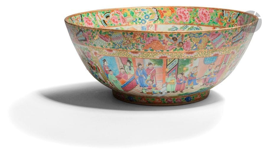 CHINE, Canton - XIXe siècle
Bol à punch en porcelaine émaillée polychrome à décor de réserves ornées de dignitaires et jeunes femmes dans des palais entourés de papillons, oiseaux et fleurs. (Fêlure). 
Diam. 40 cm