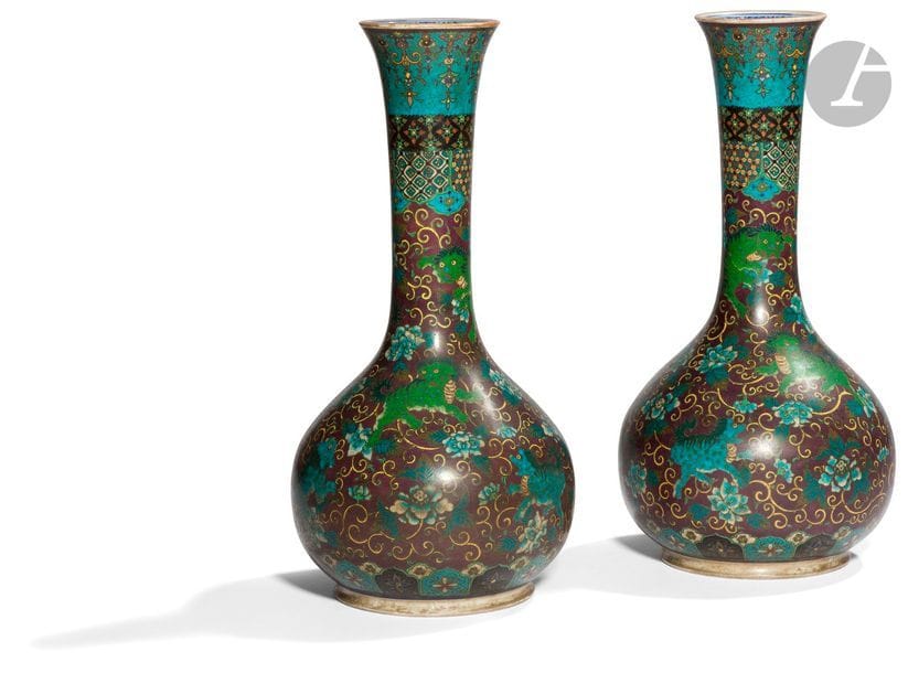 JAPON - XIXe siècle
Paire de vases bouteille en porcelaine émaillée polychrome sur fond aubergine de chimères parmi des rinceaux de lotus fleuris. Signés. 
H. 36,6 cm