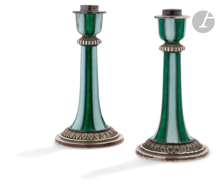 Deux petits flambeaux en argent et émail
Le fût et le vase reliés par un nœud à godrons, ornés de bandes d’émail vert pâle et vert foncé alternées. La base en argent au naturel, soulignée d’une frise de feuilles d’eau.
Poinçons : Minerve 1 titre, « FФ » suivi d’une étoile dans un losange. Marqué sur la base « ФАБЕРЖЕ » (Fabergé).
Il s’agit probablement d’un travail de la firme Fabergé française « Fabergé & Cie », vers 1950 ?
Hauteur : 11,3 cm ; Diamètre à la base : 5,7 cm ; Poids brut total : 455 g

Пара маленьких серебряных подсвечников с эмалью.
Стойка и чашка соединены ребристым узлом, украшены эмалевыми полосами светлого и темно-зеленого цвета. Основа из серебра подчеркнута фризом из листьев.
Клейма : голова Минервы с цифрой 1 (проба 950 / 1000), ромбовидной формы клеймо « FФ » со звездой. На основе внизу маркировка «ФАБЕРЖЕ».
Вероятно, работа французской фирмы «Fabergé & Cie» (Фаберже и Ко) около 1950 ? Фирма была открыта в Париже Евгением и Александром Карловичами Фаберже.
Высота : 11,3 см ; Диаметр основы : 5,7 см ; Общий вес : 455 г