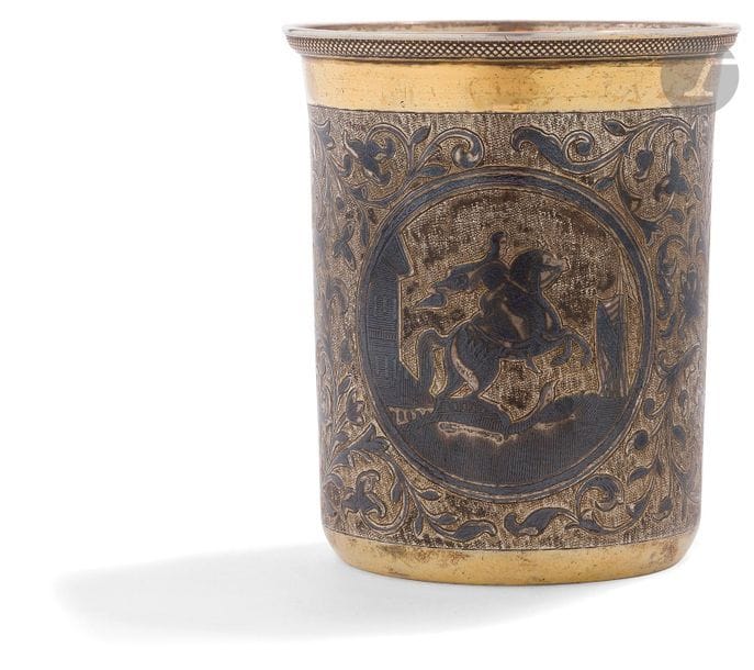 Gobelet en vermeil niellé, 1845
Gobelet à col légèrement évasé. Décor de rinceaux gravés et niellés avec deux réserves opposées avec deux monuments de Saint-Pétersbourg : d’une part, le « Cavalier de bronze » statut équestre de Pierre I par Falconet sur la place du Sénat et d’autre part, une des deux colonnes rostrales sur l’île Vassilevsky (sans doute celle de gauche en regardant la Bourse).
Poinçons : 84, Moscou, 1845, essayeur « А•К » (Andreï Antonovitch Kovalsky) et orfèvre « ее » (Efrem Evdokimov).
Hauteur : 7,5 cm ; Diamètre au col : 6,5 cm ; Poids brut : 86,9 g

Серебряный стакан с чернью. 1845 г.
Слегка расширяющийся кверху. Растительный гравированный декор с чернью и двумя медальонами с памятниками Санкт-Петербурга : с одной стороны - Медный всадник и с другой - одна из ростральных колон на Стрелке Васильевского острова (вероятно, левая, смотря на биржу).
Клейма : 84, Москва, 1845, пробирный мастер « А.К » (Андрей Антонович Ковалевский 1821 - 1856) и мастер «ее» (Ефрем Евдокимов).
Высота : 7,5 см ; Верхний диаметр : 6,5 см ; Общий вес : 86,9 г