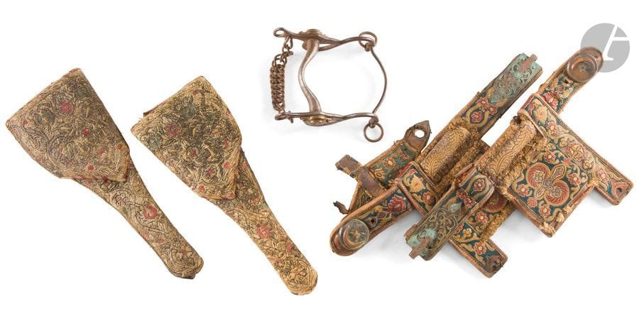 Mors d’artillerie en fer, à bossettes en laiton aux canons croisés.
IIIe République.
On y joint une paire d’œillères en cuir brodé et deux grands cobourgs en cuir finement et entièrement brodés.
Afrique du Nord. XIXe siècle.