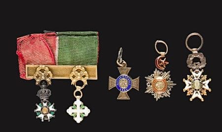 FRANCE - Italie
Barrette en or à décor de nœuds de rubans, présentant deux miniatures :
- Une Légion d’honneur Monarchie de Juillet en argent et or. 
- Une croix de Saint Maurice et Lazare en or et émail.
Éclats aux émaux. Poids brut : 4 g
Avec ruban aux couleurs des deux ordres. 
On y joint trois miniatures, une de la Couronne de Prusse en vermeil et or, une de l’ordre du Médjidié en argent et or et une de l’ordre de Charles III en or et émail. Éclats. 
T.B.