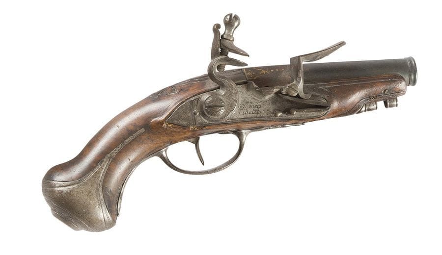Pistolet de voyage à silex. 
Canon rond à méplat décoré à l’or au tonnerre. Platine signée « Je suis fidelle ». Garnitures en fer découpé et gravé. Crosse en noyer (manque la baguette).
B.E. Vers 1780.