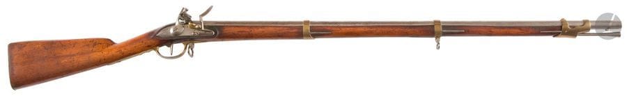 Fusil de pupille ou d’enfant à silex modèle An IX. 
Canon rond à méplats au tonnerre. Platine à corps plat. Chien à corps rond. Garnitures en laiton. Battant en fer. Crosse à joue. Baguette en fer.
Longueur : 113 cm