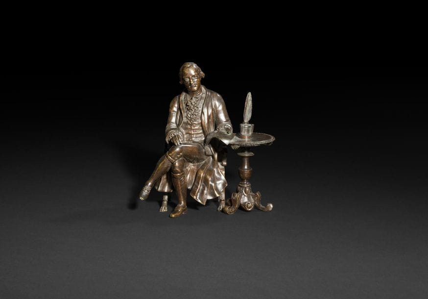 Groupe en bronze à patine brune représentant un homme en habit du XVIIIe siècle attablé à un guéridon ; (fragment).

XIXe siècle.

H : 20 cm