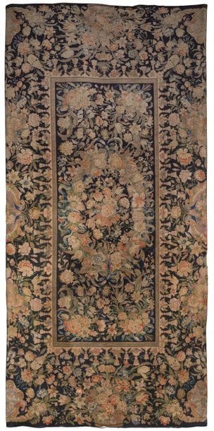 Tapis au point en laine, la partie centrale à décor sur fond bleu d'une couronne fleurie rubanée, bouquets, large bordure à fond bleu à décor de fleurs et corbeilles de fleurs.

Style Louis XIV

435 x 102 cm 

Accidents