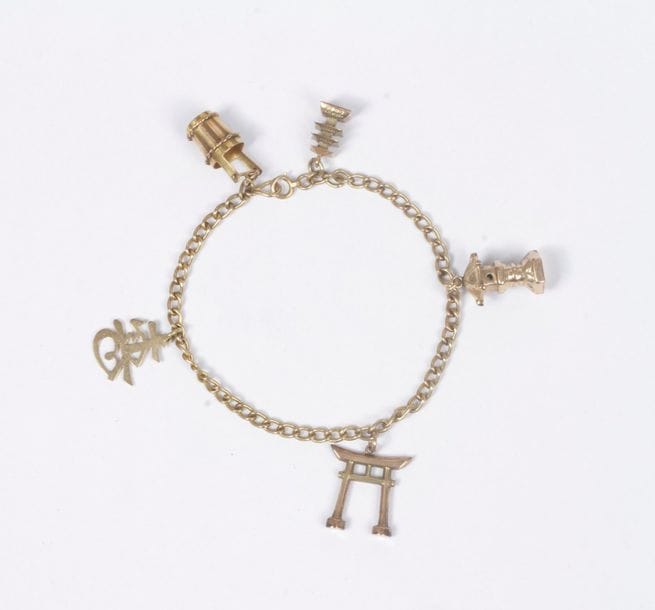 Bracelet en or 14K (585) retenant en pampilles 5 charms en or 14K sur le thème de l'Asie (pagodes, portique de temple, idéogramme…). Poids : 11,8 g
