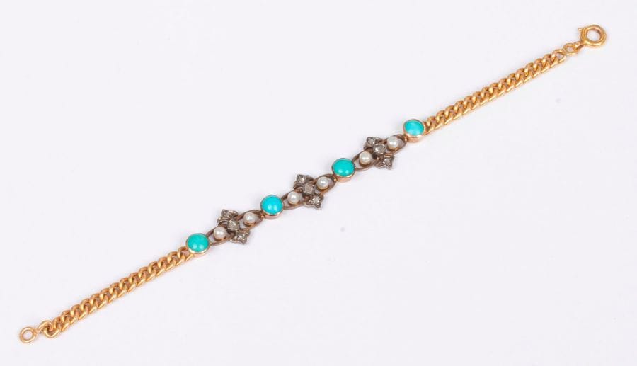 Bracelet en or 18K (750) articulé de maillons gourmettes, orné de motifs en argent sertis de diamants taillés en roses, de perles boutons alternés de turquoises cabochons. Travail français du début du XXe siècle. Longueur : 16 cm environ. Poids brut : 7 g