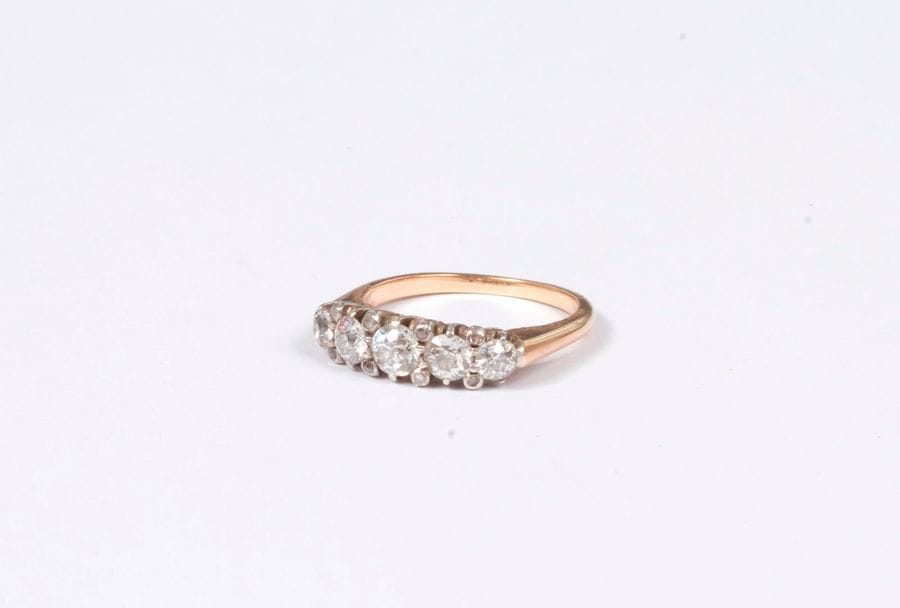 Bague en or 18K (750), ornée d'une ligne de 5 diamants ronds de poids croissant scandés de petits diamants taillés en roses. Tour de doigt : 53/54. Poids brut : 4,1 g (égrisures)