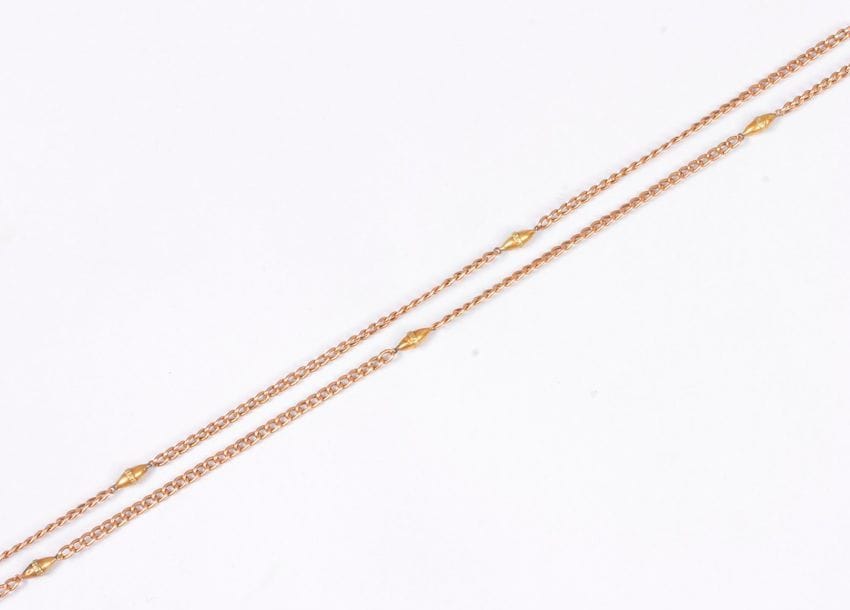 
Longue chaîne en or 18K (750) ponctuée de motifs ovales. Poids : 21,5 g (on joint une chaîne et un pendentif en métal orné de feuilles de liseron)