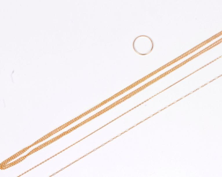 Lot de bijoux en or 18K (750) comprenant : un sautoir, deux fines chaînes et une alliance. Poids : 19,9 g (on joint un bris d'or)