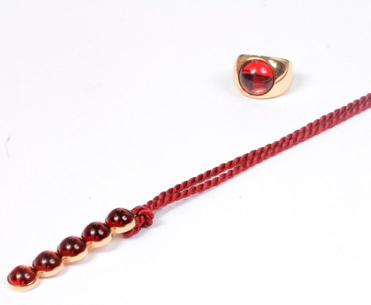 LALIQUE. Demi-parure en métal doré et perles de verre rouge. Signée. Dans son écrin