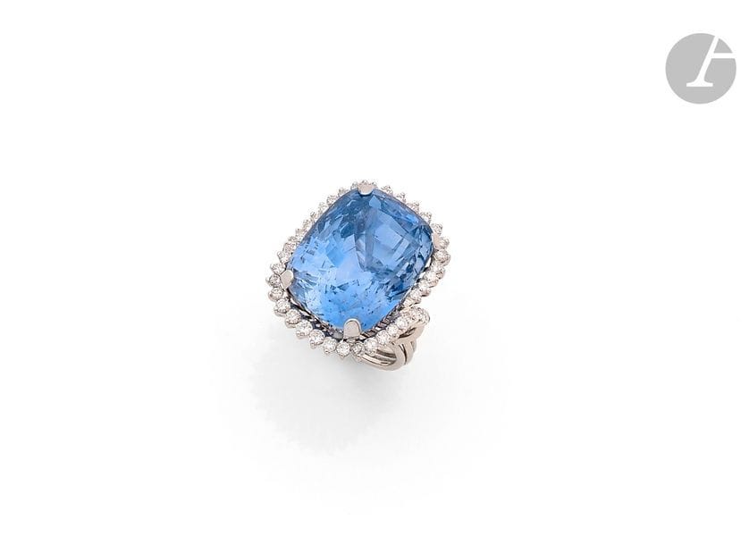 Bague en fils d’or gris 18K (750), ornée d’un saphir facetté de taille coussin mixte pesant 41,8 cts entouré de 42 diamants ronds de taille brillant. 
Tour de doigt : 52/53. 
Poids brut : 17,1 g
 Le saphir accompagné d’un rapport GEM Paris attestant : origine Sri Lanka, pas de modification ou traitement observé (S1)