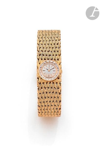 OMEGA pour O. J. PERRIN
Montre bracelet de dame en or 18K (750), cadran rond, index bâtons, bracelet tressé en or 18K, mouvement mécanique. Dans son écrin. 
Longueur : 17,5 cm environ. 
Poids brut : 80,9 g