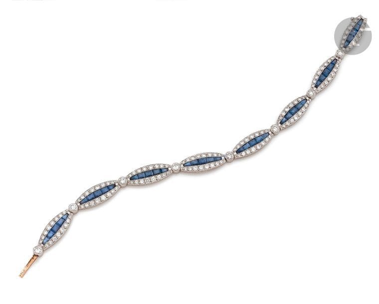 Bracelet en or 18K (750) et platine, articulé de 8 maillons ovales sertis d’une ligne de saphirs calibrés entre deux lignes de diamants ronds. 
Longueur : 18 cm environ. 
Poids brut : 17,1 g