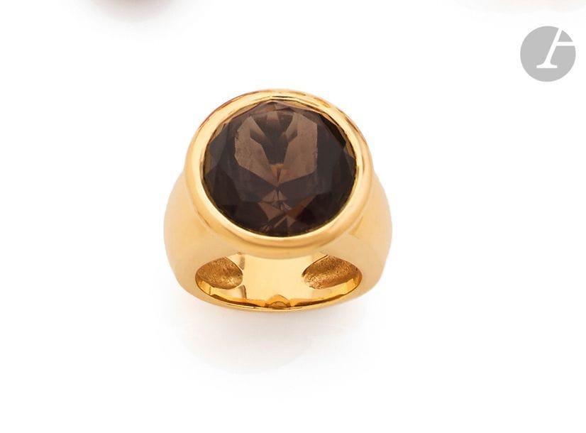 Large bague en or jaune 18K (750), ornée d’un quartz fumé rond serti clos. 
Tour de doigt : 57. 
Poids brut : 29,5 g