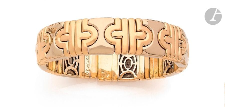 Bracelet torque orné de motifs en or jaune et gris 18K (750) imbriqués. 
Dimensions : 1,5 x 17 cm environ. 
Poids brut : 76,6 g (âme en acier)