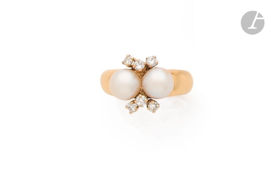 Bague en or jaune 18K (750), ornée de deux perles de culture crème agrémentées de 6 diamants ronds. 
Tour de doigt : 54. 
Poids brut : 11,1 g